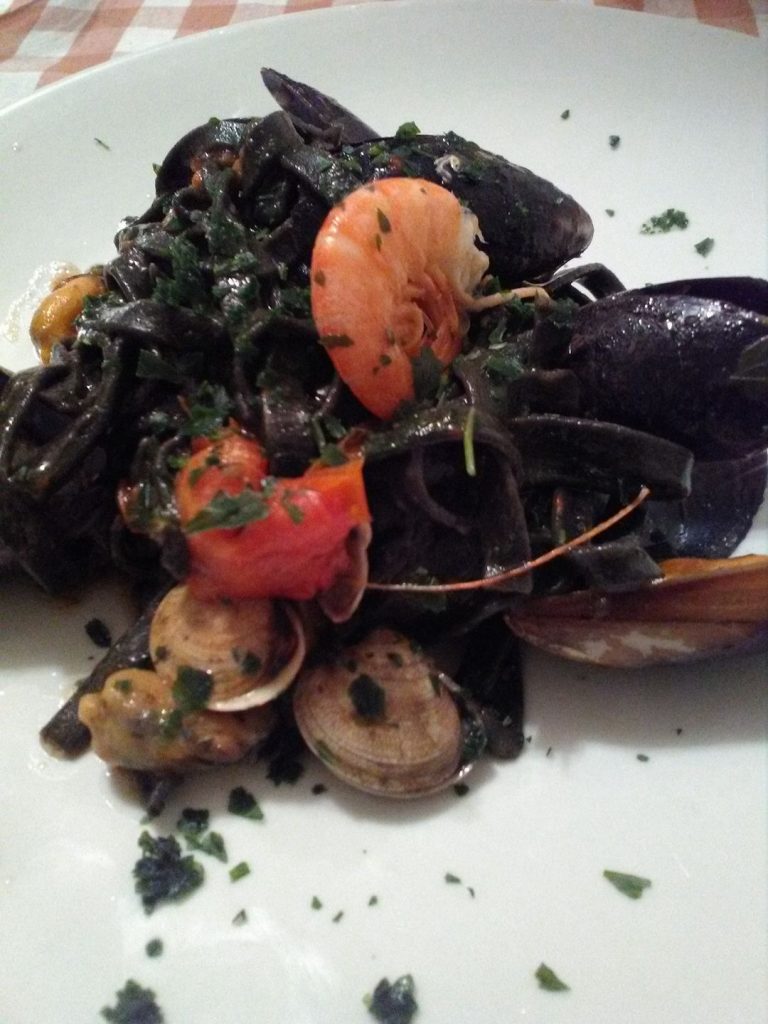 Tagliatelle al nero di seppia con frutti di mare e pomodorini