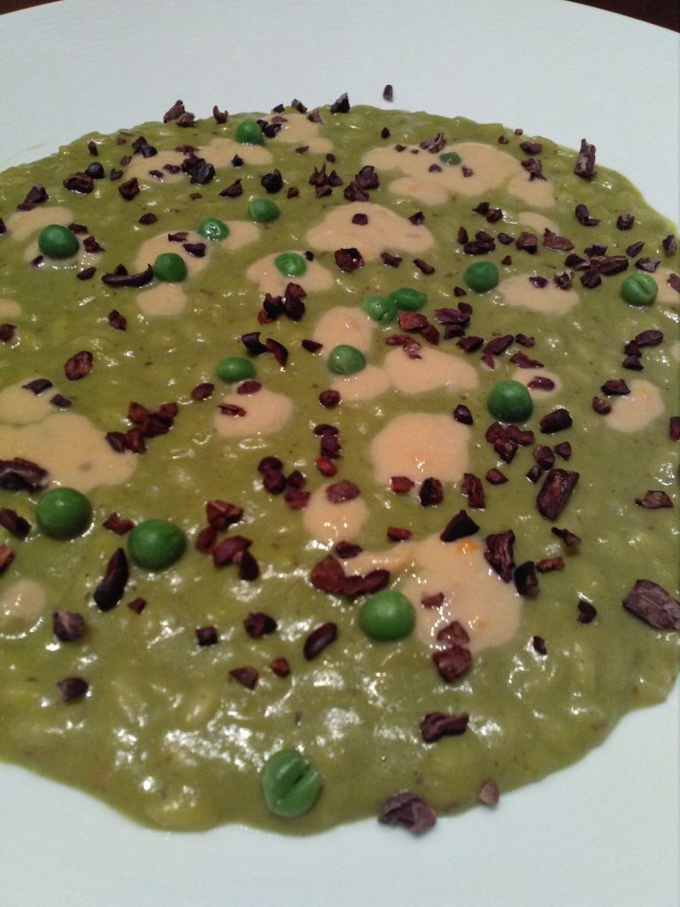 Risotto mantecato alla crema di piselli, salsa di coralli e fave di cacao
