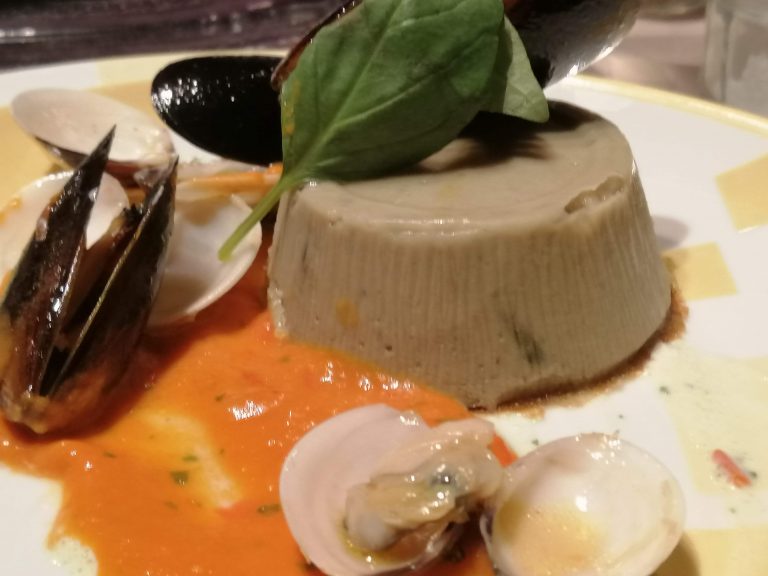 Budino di melanzane con cozze e vongole in salsa di datterini e basilico