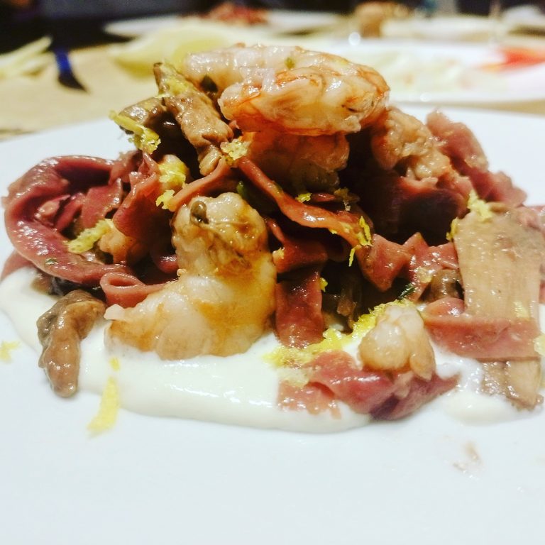 Tagliatelle alla barbabietola con gamberi e porcini su fonduta di caprino e zest di limone